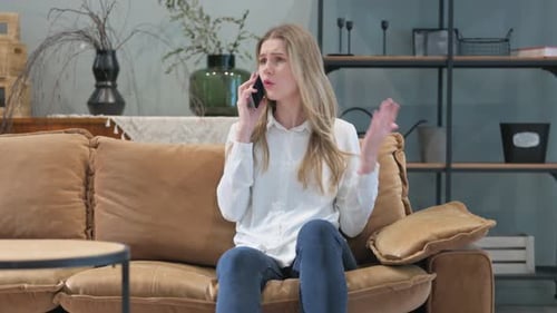 Woman Talks on Smartphone While Sitting on Couch