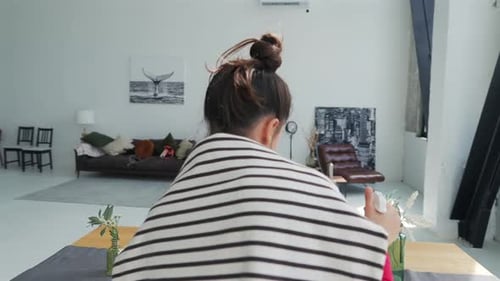 Young Woman Watering Plants in Modern Apartment