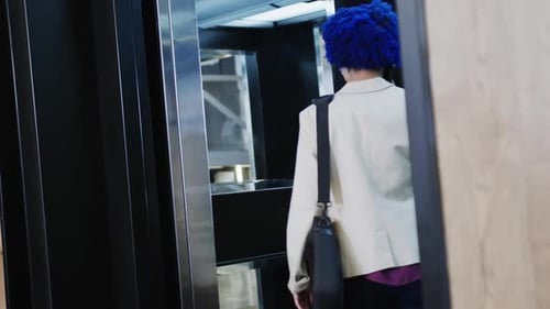 Woman Talks on Phone in Modern Elevator