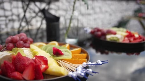 Nahaufnahme von Tellern mit verschiedenen Obst- und Beerensorten auf einem Buffettisch. Essen in Buffetform