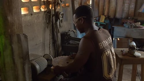 working class labor conditions of black labor in africa, young male working in a metallurgic factory
