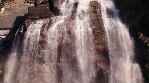 Aerial View of Stunning Waterfall Cascading Down Rocky Cliff