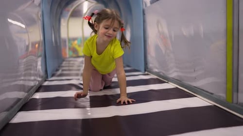 Happy Little Girl Crawling Through Tunnel on Children's Play Centre