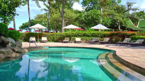 Beautiful umbrella and chair around swimming pool in hotel and resort - vacation concept