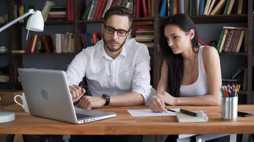 Two Beautiful Students Brainstorm Work By Discuss With Desktop In Trendy Loft Close Up With Backg...