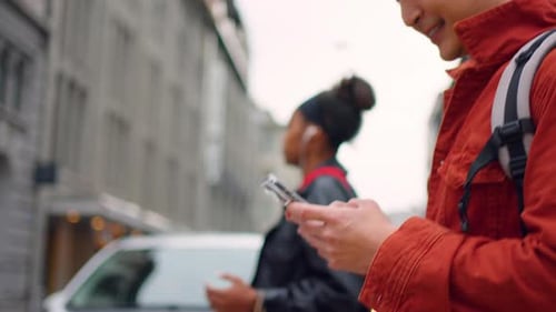 Close up of young man backpacker chatting on phone while walk in city.