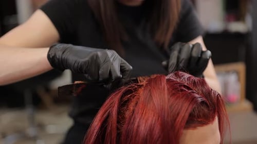 Hairdresser Applying Red Hair Dye in Salon