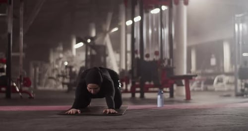 Muslim Sportswoman Stretching Back in Gym