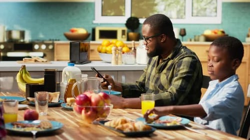 Man and Boy at Table Having Breakfast