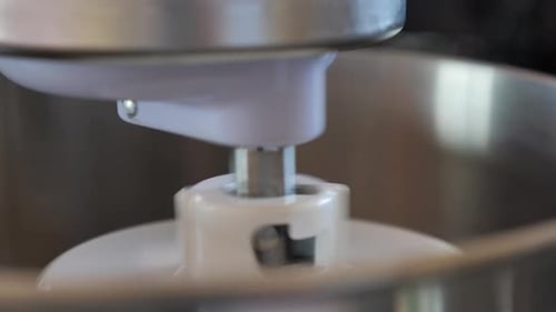 view of purple kitchen beater appliance mixer rotating round beating recipe in circular motion