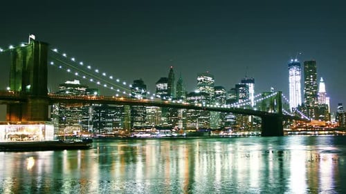 View Of Manhattan Skyline And Brooklyn Bridge At Night. Time Lapse