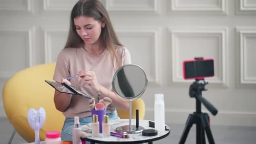 La bloguera de belleza Woman está filmando un tutorial de Makeup para su canal que muestra sombras de ojos