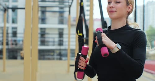 Close Up of Young Woman Training with Dumbbells at Sports Ground Fitness Concept