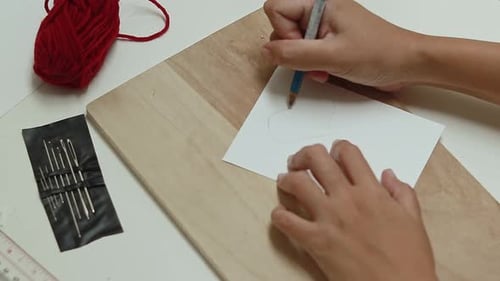 Hands Tracing Outline on Paper with Pencil