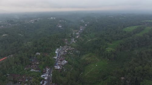 Aerial view of lush rice fields and village at sunset, Bali.