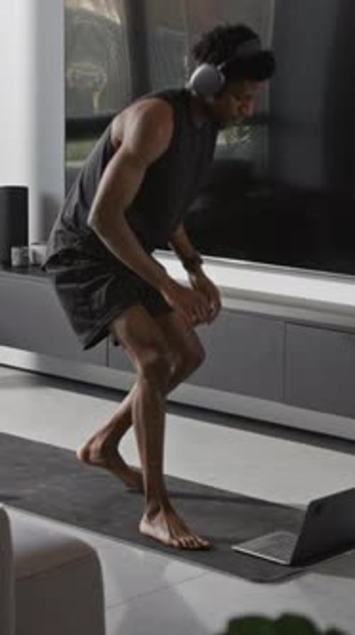 Man Works Out on Yoga Mat at Home