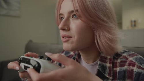 Woman Plays Video Game Indoors on Couch