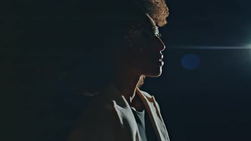 Person with Stylized Makeup in Dark Setting