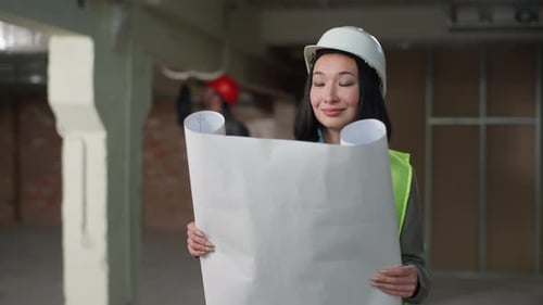 Japanese Woman Architect Business Construction Plan Blueprint Foreground Renovation Caucasian Man