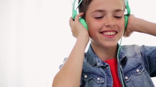 Smiling Boy Listening to Music with Teal Headphones