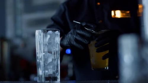 Bartender Pours Yellow Drink from Shaker into Glass