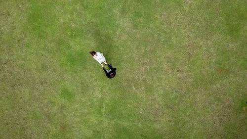 Couple Swirling together in the Grass Top View Drone Footage