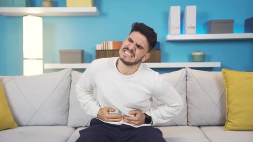 Young Man Suffering From Stomach Pain at Home