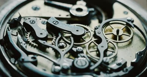 Slow motion close up of a professional watchmaker repairer working on a luxury mechanism watch gea