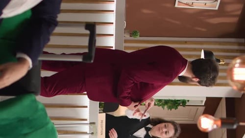 Hotel Receptionist Attending to Guests in Hotel Lobby