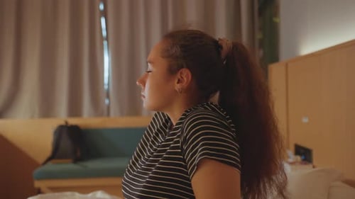 Woman Lying Down on Bed in Hotel Room