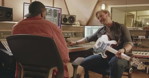 Musiciens masculins composant dans un studio d'enregistrement de musique