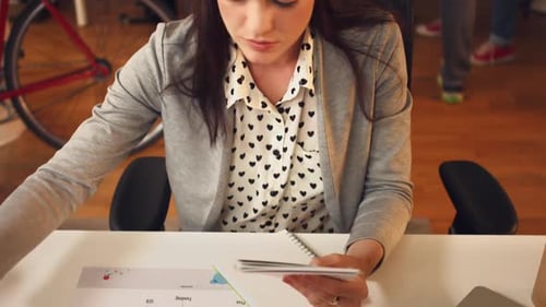 4k video footage of a young designer looking at colour swatches and photographs in an office