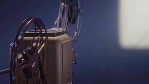 Vintage Movie Projector Showing Film in Dim Room