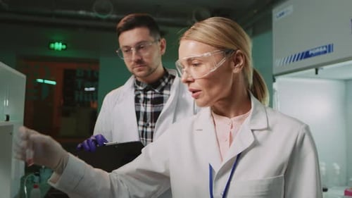 Scientists Inspect Test Tube Sample in Lab Setting