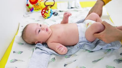 Loving Parent Changing Infant on Table Indoors