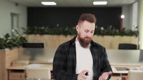 Adult Using Hand Sanitizer in Office
