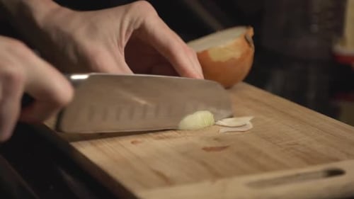 Chopping A White Onion Into The Wooden Chopping Board For Cooking. - close up shot