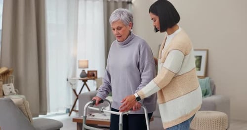 Supportive Young Woman Helping Senior with Walker