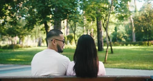 Affectionate Couple Snuggling on a Bench in Park