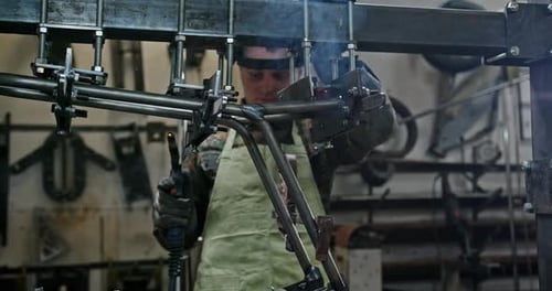 Man in Helmet Welding Metal Mechanism in Workshop Man in Apron and Protective Shield Welding and