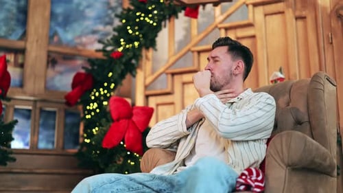 Man in chair with sore throat at Christmas