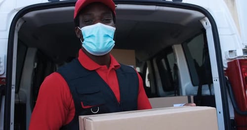 African delivery man with face mask delivering packages in South Africa truck