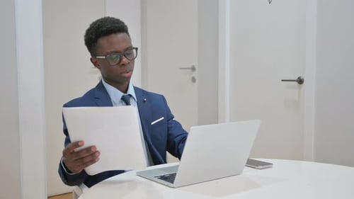 Young Adult Working at Table with Papers