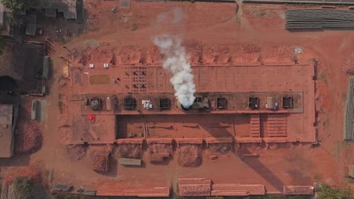 Aerial view of industrial brick kilns with smoke clouds in Bangladesh