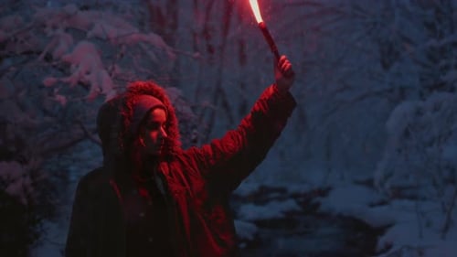 A Young Girl Holding a Burning Signal Fire A Woman in a Winter Forest Lights a Red Rescue Flare