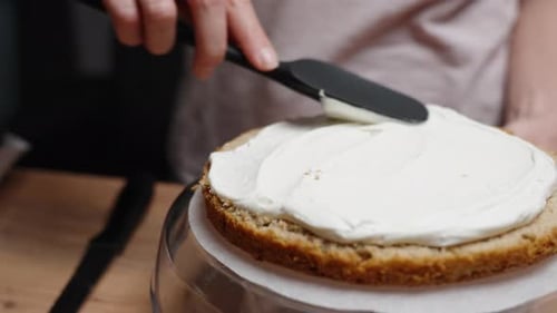 Woman Frosting Cake with White Cream