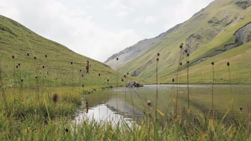 Child Hikes Near Lake in Verdant Mountains