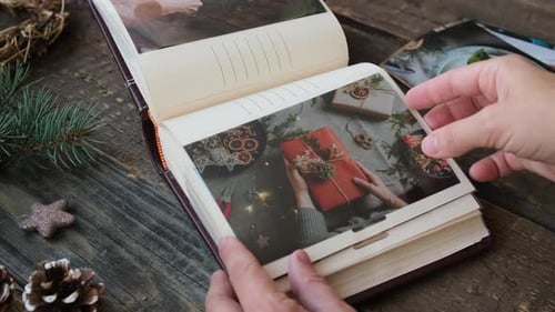Una persona mira fotos navideñas impresas en un álbum de fotos familiar