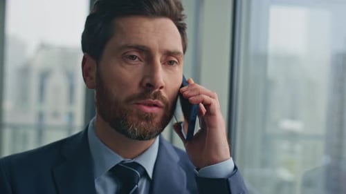 Confident Businessman Speaking Cellphone at Panoramic Window Office Closeup