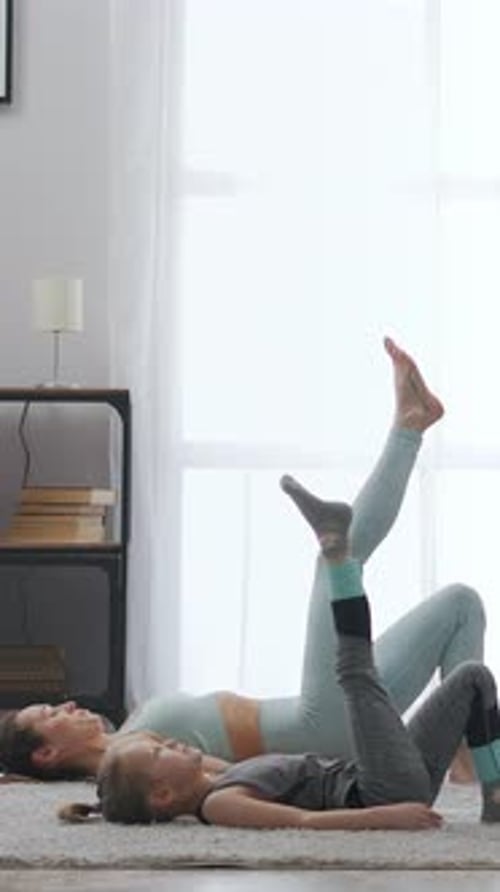 Woman and Child Doing Leg Raises in Living Room